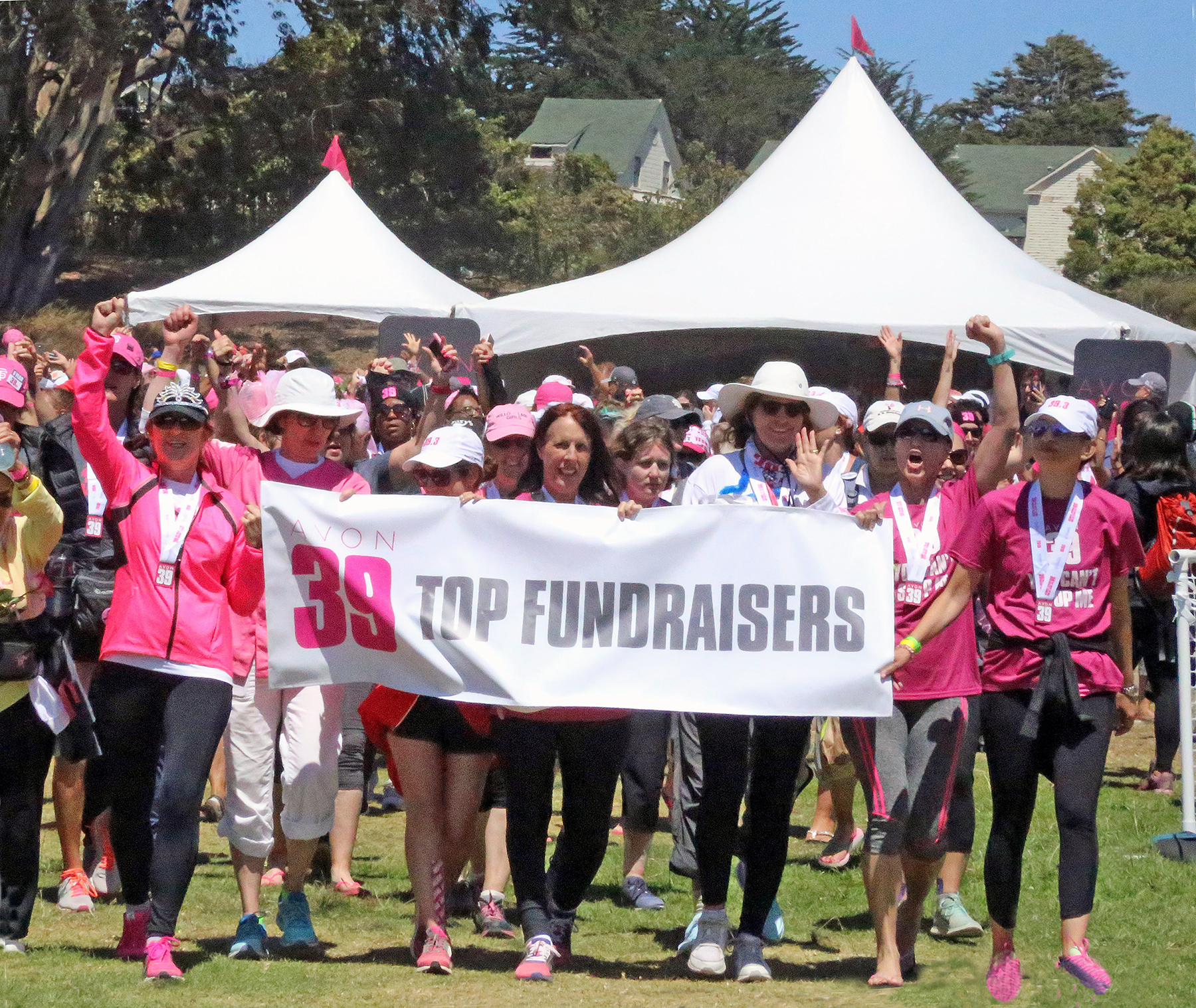 Dr. Alisa Gean, holding the Top Fundraisers banner on the far left, raises a hand in support of the fight against breast cancer.