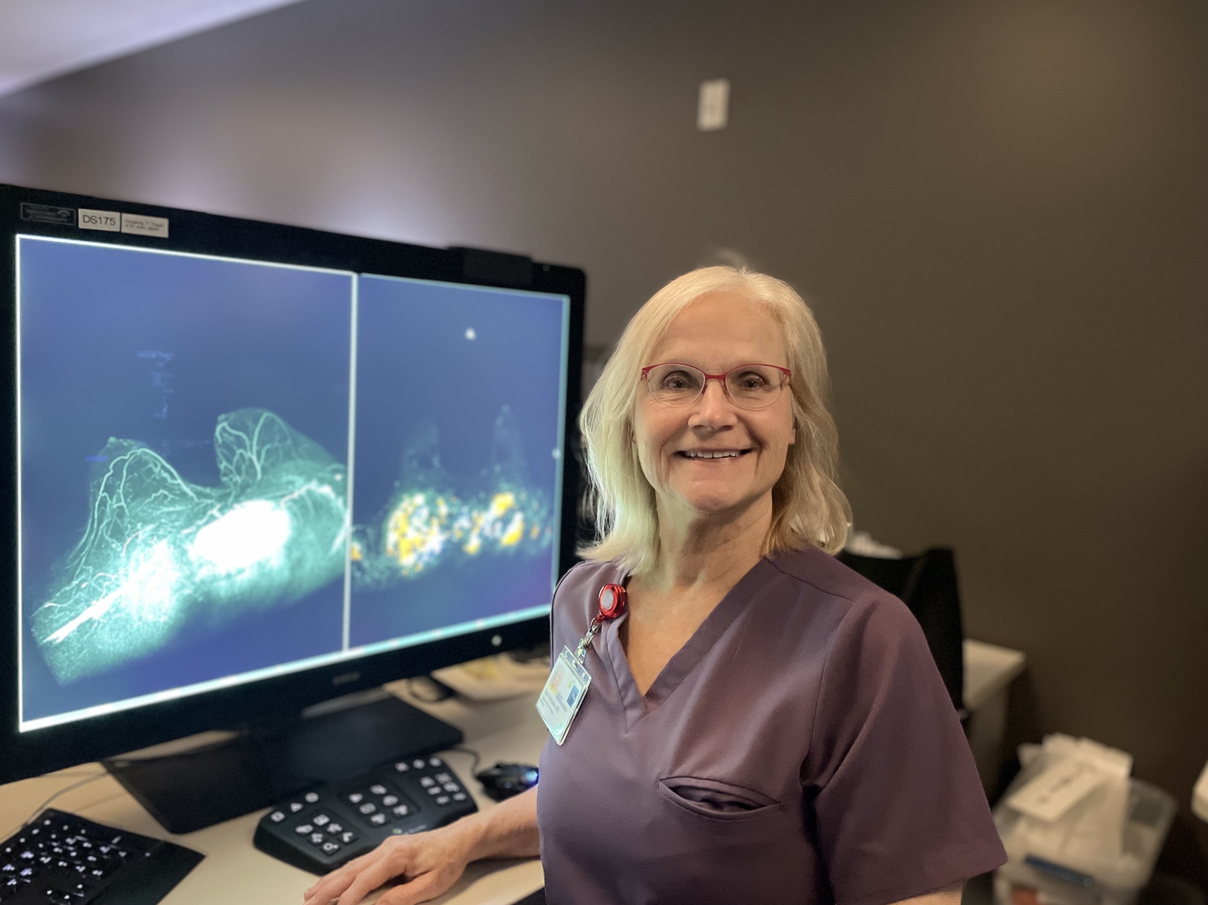 Rita Freimanis, MD, Professor. A woman smiling in front of a computer workstation.