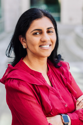 Researcher Pavithra Viswanath, PhD wearing a red blouse with a blurred background
