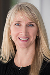 Professional headshot of a woman with long straight blonde hair smiling softly.