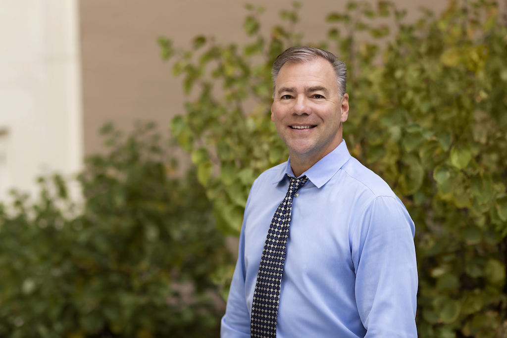 Jeff Geiger, Director of Imaging Services – Pediatrics at UCSF Health. Man smiling at camera outdoors at UCSF's Parnassus Heights campus.