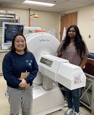 Two students beside a small bore MRI