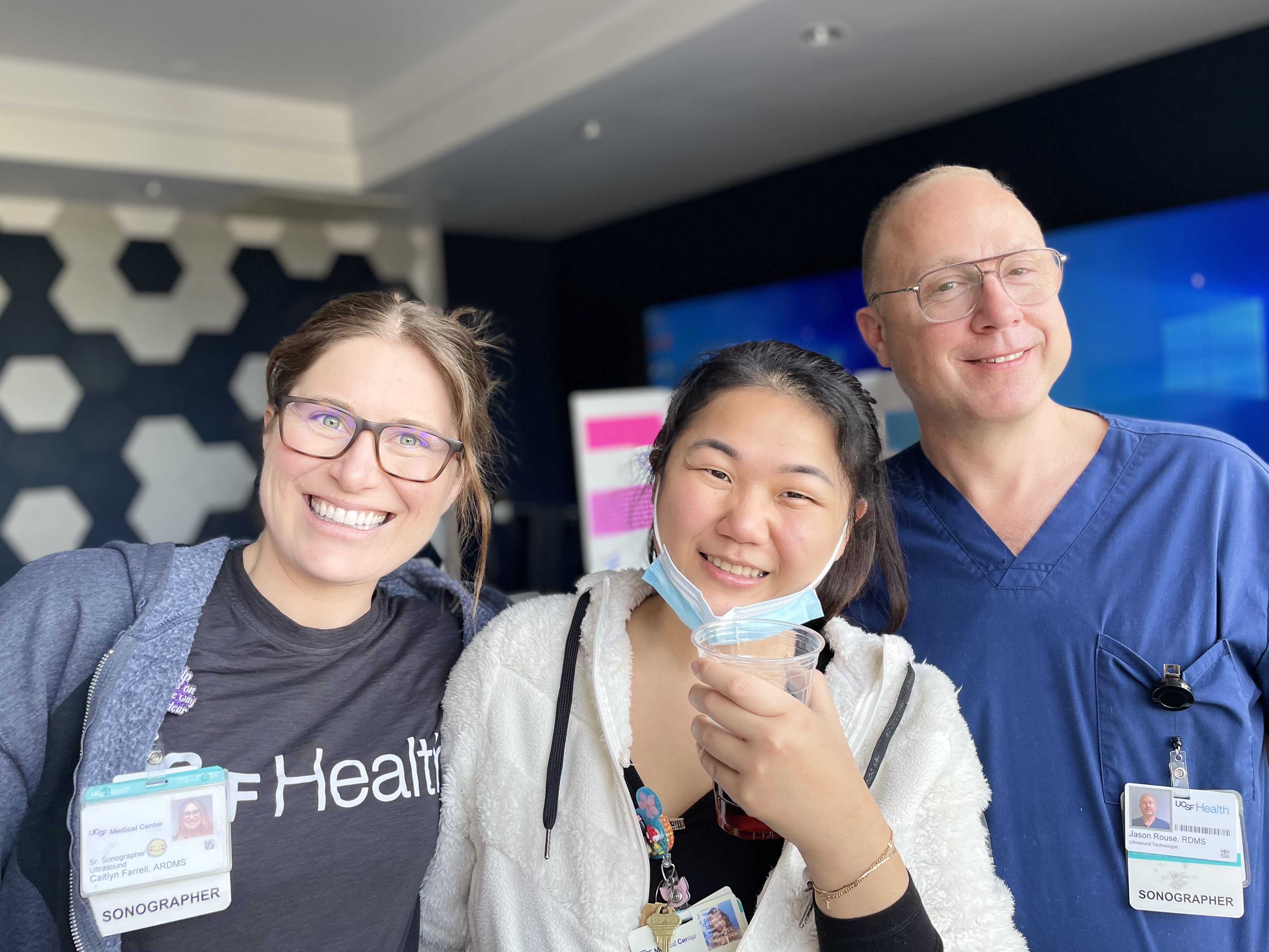 Sonographer Caitlyn Farrell joins Ultrasound Technologists Irene Sun and Jason Rouse during Patient Safety Week activities at UCSF Parnassus Heights. Two women and a man from the Radiology team gathered together smiling.