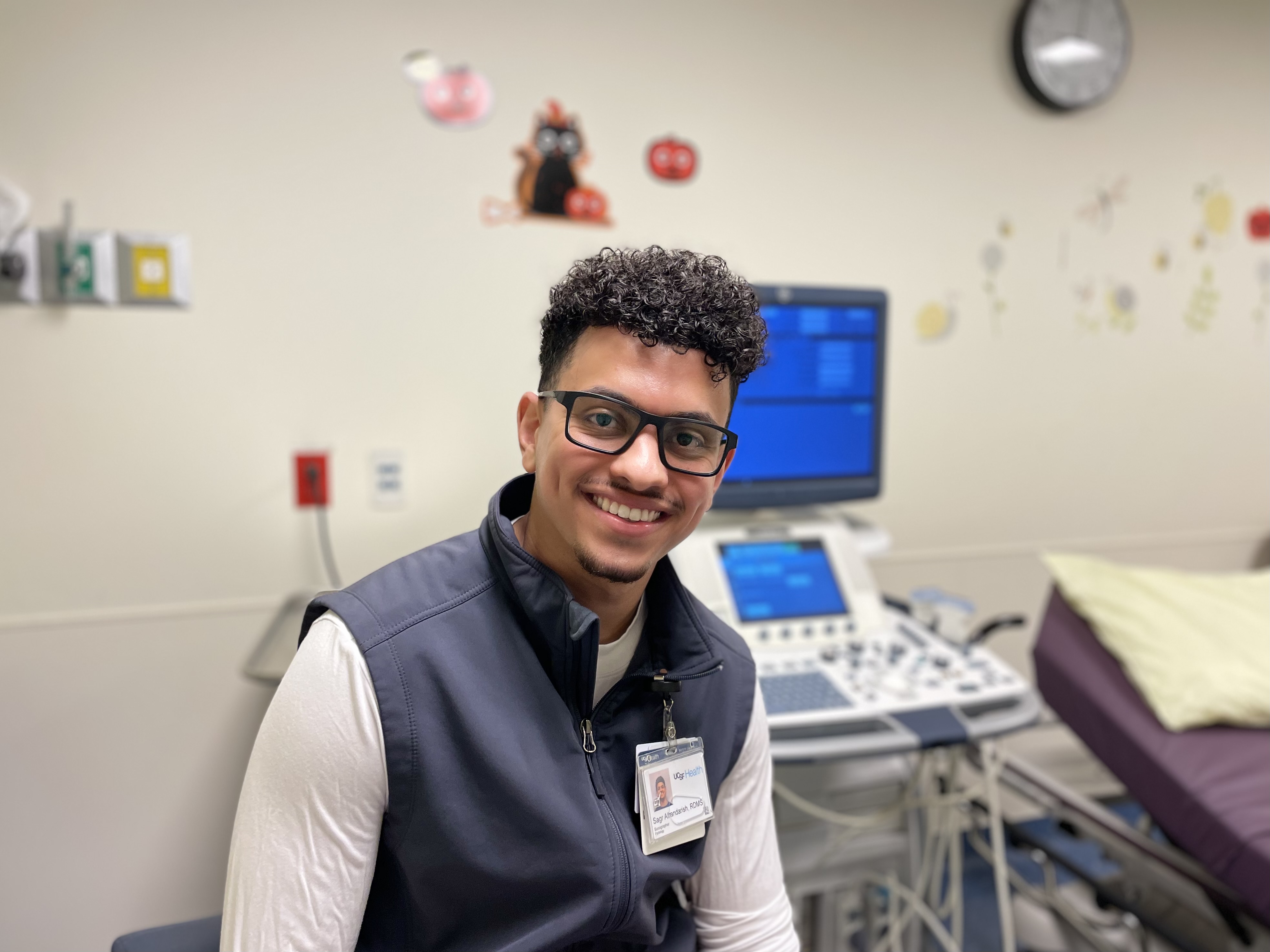 Ultrasound Sonographer Sagr Alhandarish, RDMS, Mission Bay. Man smiling in hospital exam room.