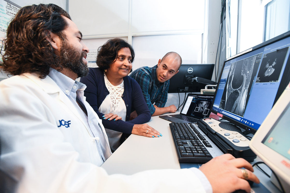 Radiology Vice Chair Sharmila Majumdar, PhD, (center) who will run the Center for Intelligent Imaging's operations, discusses artificial intelligence aided images with colleagues. Assistant Professor of Clinical Radiology Javier Villanueva-Meyer, MD, (left) and computational research data scientist James Hawkins (right).