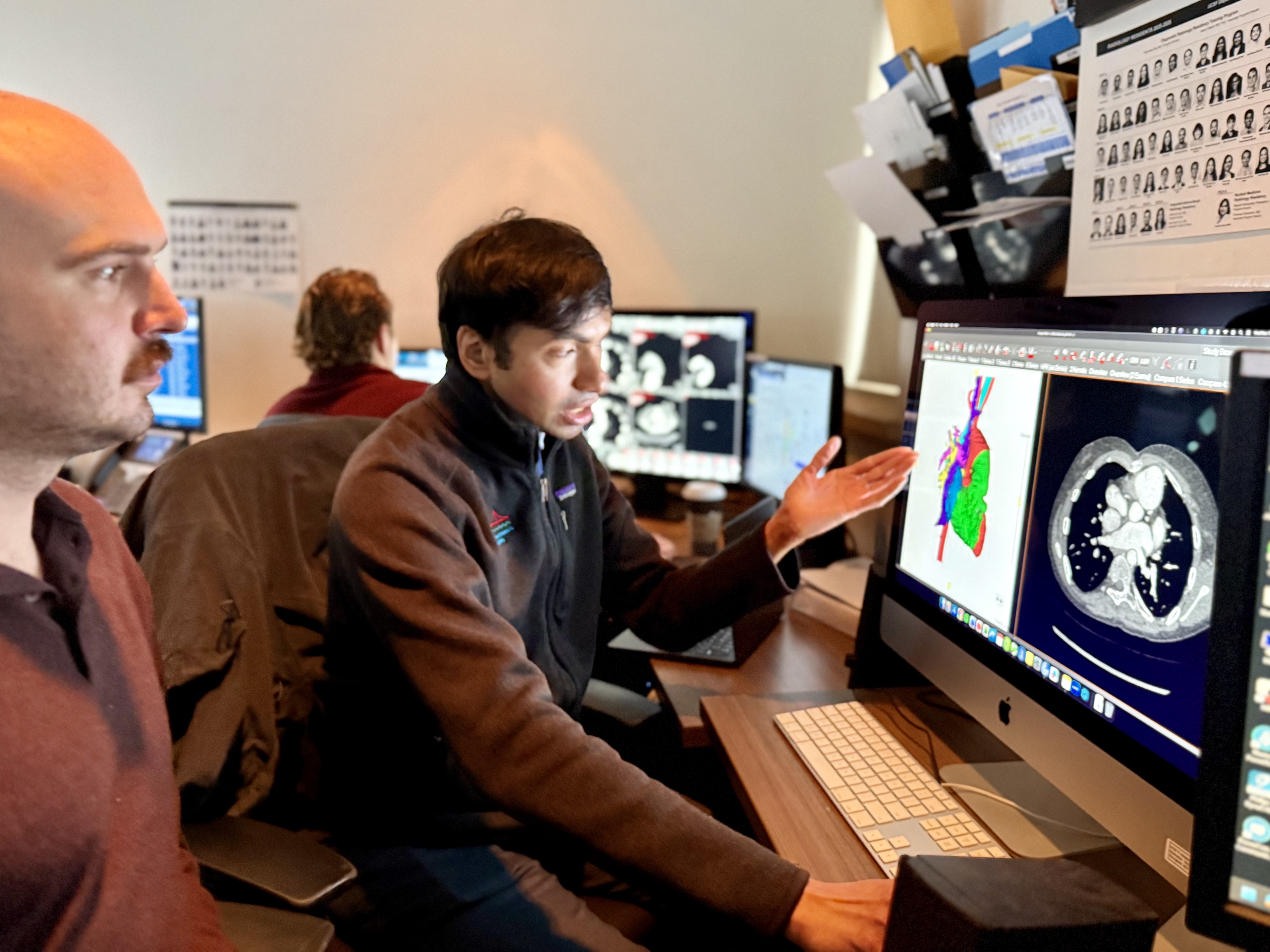 Radiologists reviewing scans in reading room.