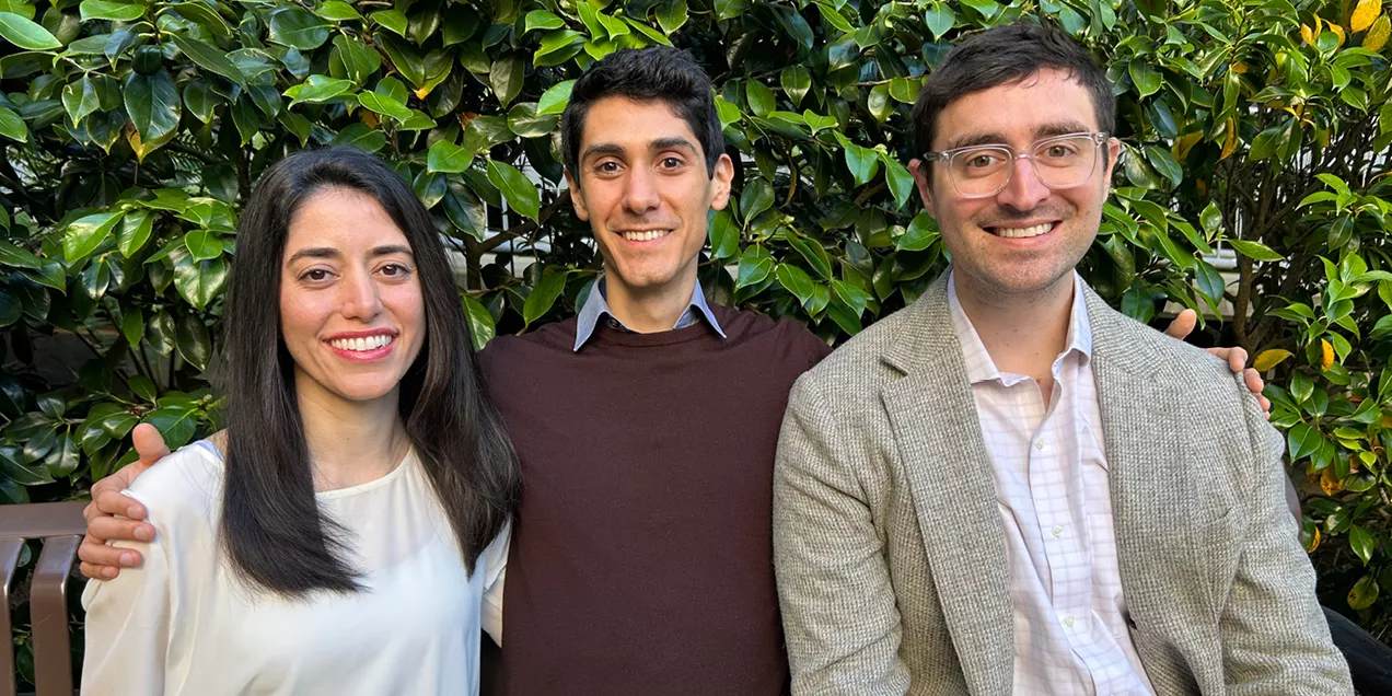 Three chief residents posing together outdoors with trees and foliage behind them