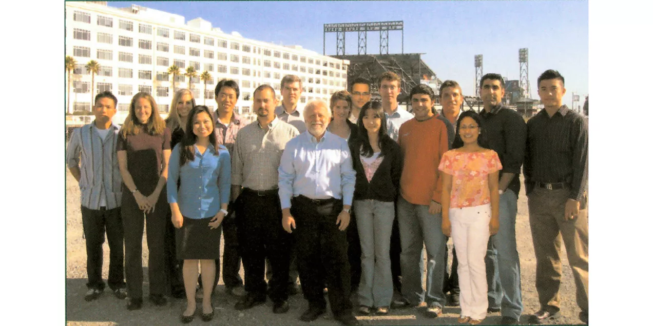 A group of researchers and colleagues pose together outdoors near the UCSF Mission Bay campus