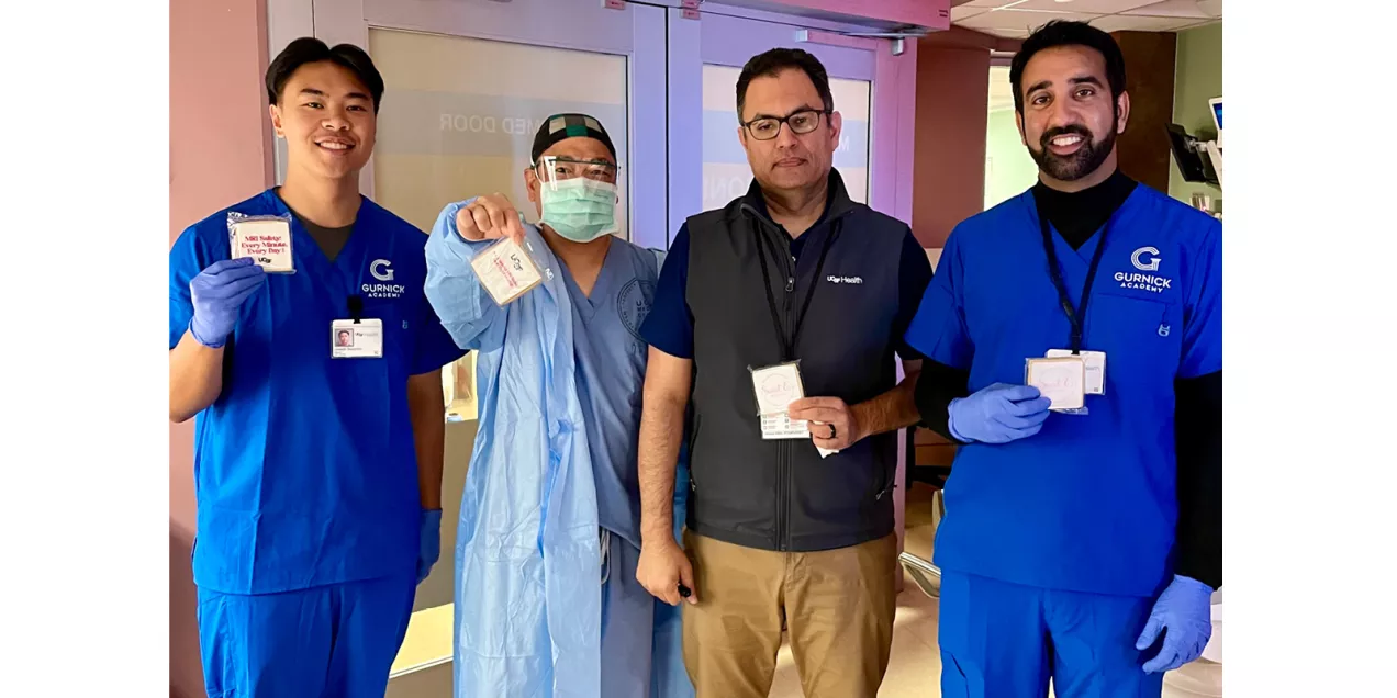 Four healthcare professionals stand together in a clinical setting, each displaying an MRI Safety Week treat.