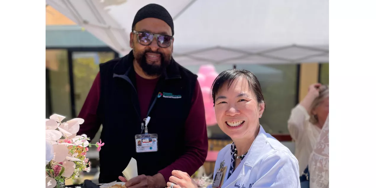 Cancer-Gallery-5.jpg Two health care staff members smile together under a canopy at an outdoor event.