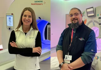 Two medical professionals stand in separate MRI suites. On the left, a woman with long brown hair smiles with her arms crossed in front of a Siemens Healthineers scanner. On the right, a man with glasses and a short beard smiles slightly while wearing a hospital badge and vest in a brightly lit pediatric imaging room