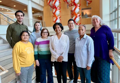 Research team standing in hospital atrium representing precision oncology and imaging collaboration