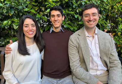 Three chief residents seated outdoors smiling with greenery background