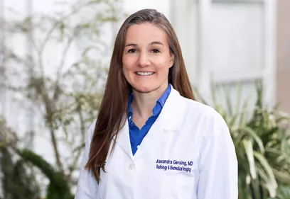 Portrait of physician in white coat standing in clinical setting