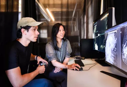 Researchers Maggie Chung and Adam Yala look at a mammogram scan on a computer screen.