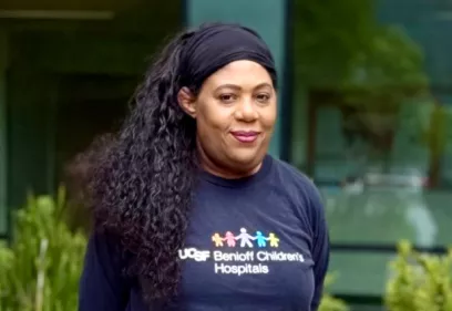 Woman wearing a UCSF Benioff Children's Hospitals T-shirt outdoors.