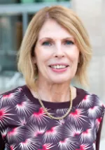 Professional headshot of a woman smiling, photographed outdoors