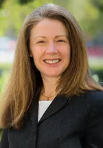 Woman smiling outdoors in a professional portrait.