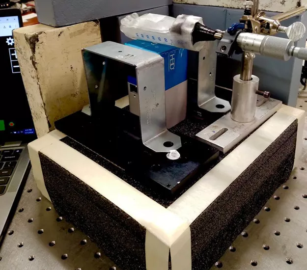 Laboratory imaging setup showing a small SPECT detector mounted on a precision positioning stage, aligned with a sample holder and shielding materials on an optical table, used for quantitative radiotheranostics imaging experiments.