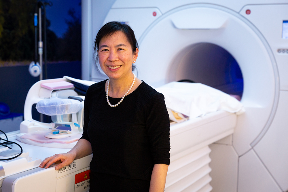 Woman in black in front of an MRI machine