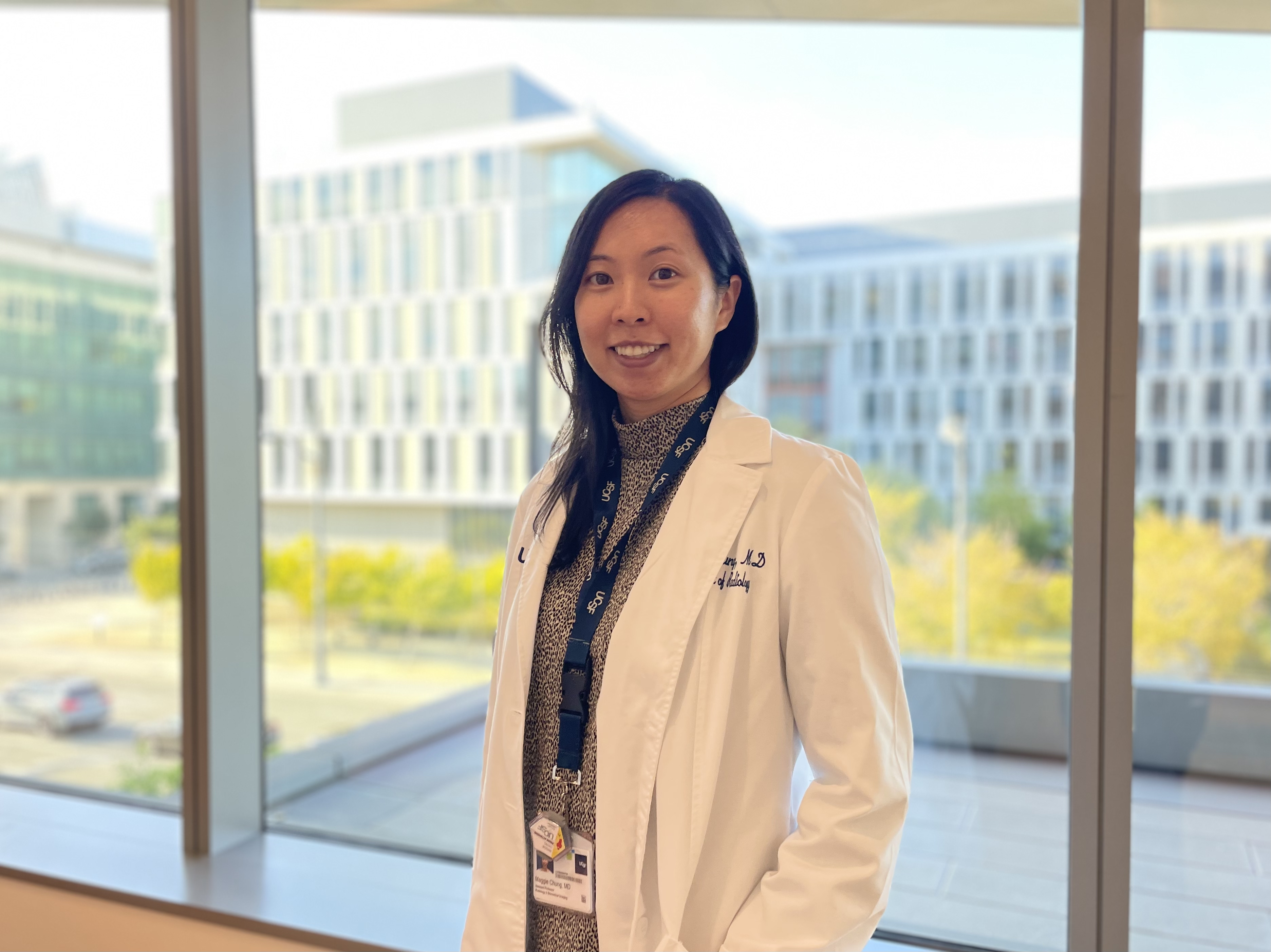 A woman smiling at UCSF Health's Precision Cancer Medicine Building in Mission Bay.