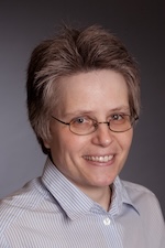 woman with short hair and glasses smiling