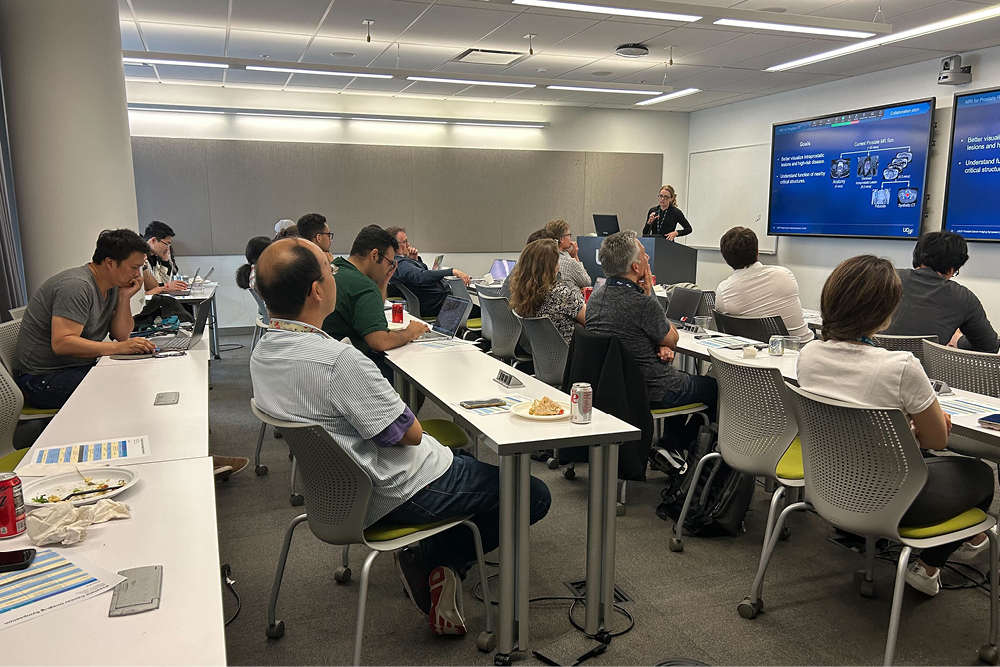 people sitting in a classroom listening to a presentation.